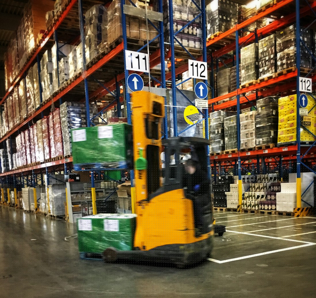 Forklift moving palletized goods in a bulk warehouse